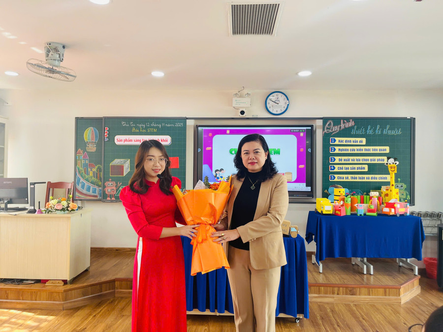 Bà Trần Lưu Hoa (phải) - Phó Giám đốc Sở GD&ĐT Hà Nội tặng hoa chúc mừng thành công của tiết dạy chuyên đề cấp Thành phố cho cô Trần Thanh Hà. dong-7.jpg