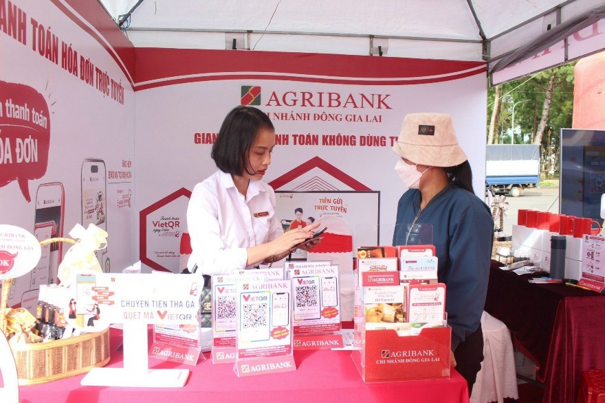 Cán bộ Agribank đang tư vấn phương thức thanh toán không dùng tiền mặt cho khách hàng