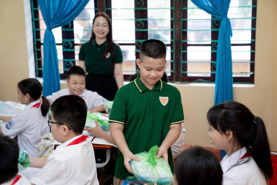 Em Phan Vũ Bình Minh, học sinh Iris School đập lợn đất góp tiền ủng hộ các bạn bị ảnh hưởng do mưa bão và lũ.