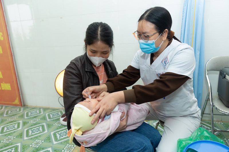 Cán bộ y tế cho trẻ uống vaccine Rota. Ảnh: Chí Hiếu