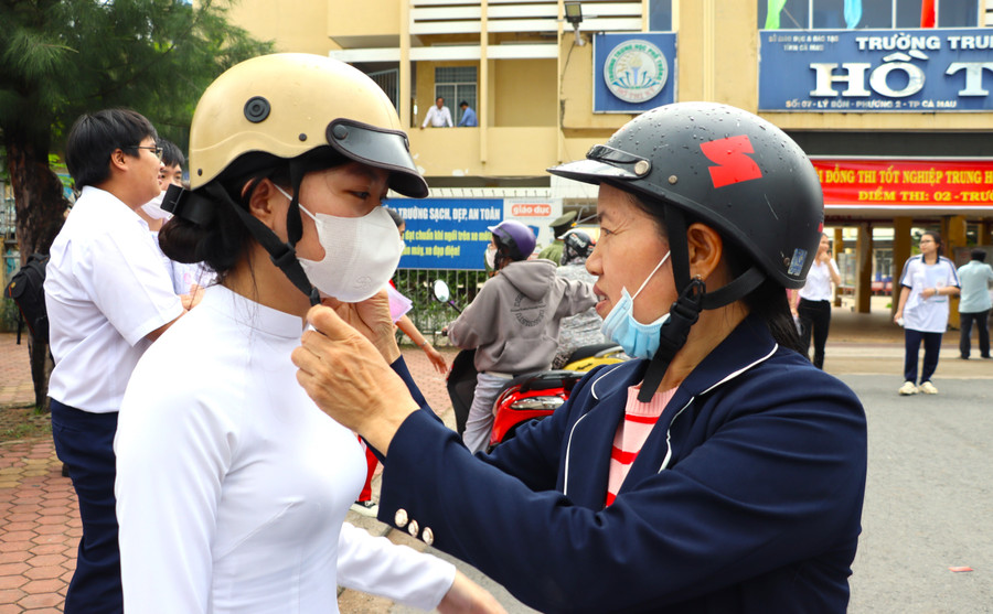 Thí sinh cùng phụ huynh tại điểm thi Trường THPT Hồ Thị Kỷ, TP Cà Mau (tỉnh Cà Mau).