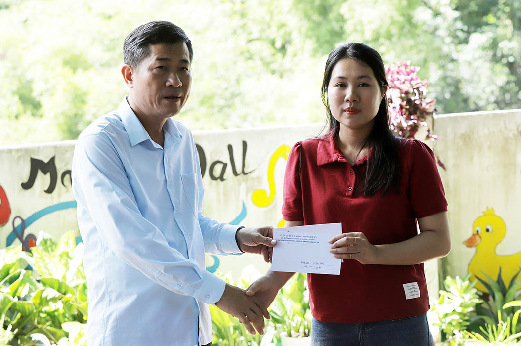 Giám đốc Sở Giáo dục và Đào tạo Nghệ An Thái Văn Thành trao hỗ trợ cho giáo viên vùng lũ. Ảnh: Quốc Huy
