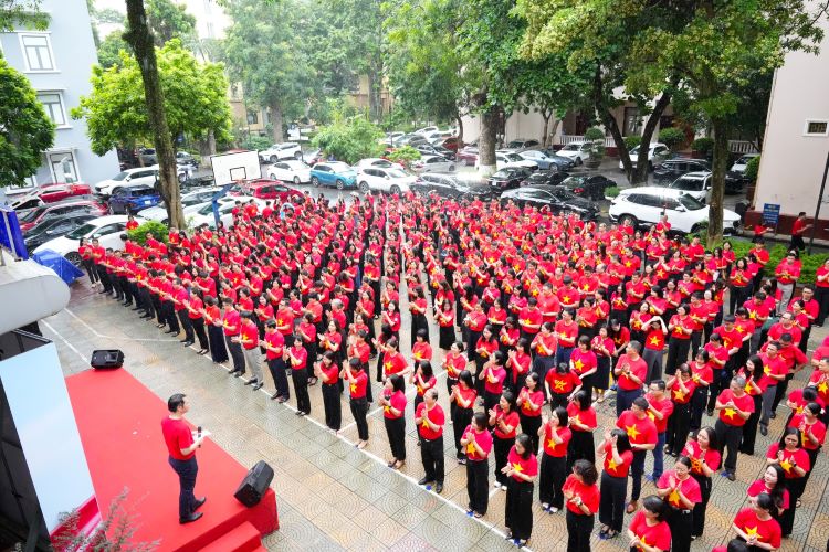 Cán bộ, giảng viên, nhân viên Học viện Ngân hàng mặc áo cờ đỏ sao vàng trong buổi lễ chào cờ đầu tuần. Ảnh: Nhà trường cung cấp