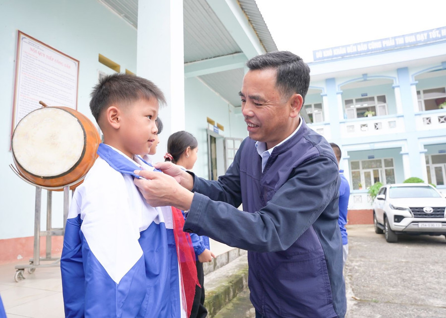 Ông Nguyễn Minh Hiệu trao áo ấm cho học sinh. ao-am-tan-uyen-2.jpg