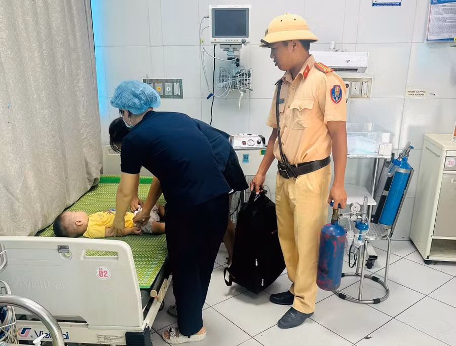 Trung tá Ngô Văn Quỳnh hỗ trợ đưa cháu bé bị co giật vào bệnh viện cấp cứu.